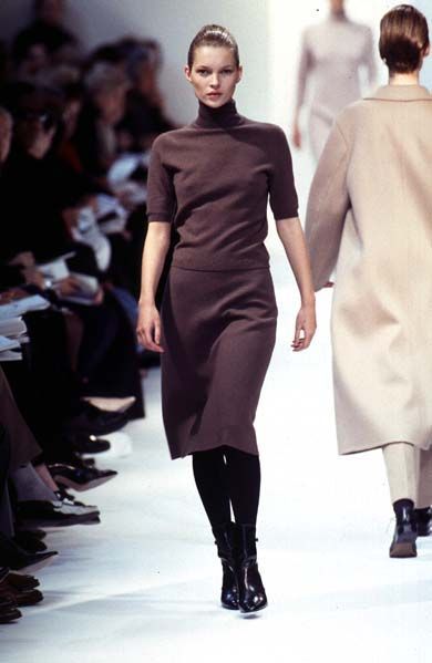 Minimalist brown office outfit featuring an oversized high neck top and wool skirt.